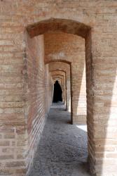 A woman walks under the narrow arches