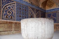 A large stone bowl and mosaics in the background