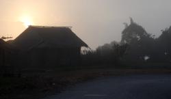 Sun rising over a farmhouse