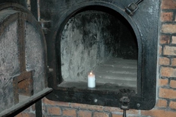 A candle burning in one of the incinerators used to cremate bodies after people were gassed to death
